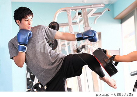 ミットにキックを打つ男性とトレーナー ミットにキックを打つ男性とトレーナー 68957508