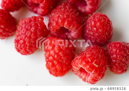 A picture of a few raspberries lies on a white A picture of a few raspberries lies on a white 68958328