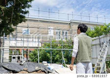 工事現場でスマホを使う作業員の男性 工事現場でスマホを使う作業員の男性 68961937