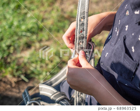 Girl horse rider is preparing horse bridle 68963525