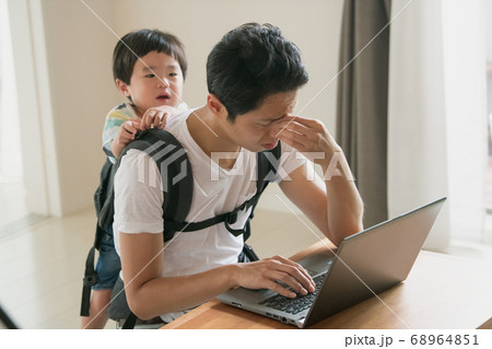 子供の世話をしながら在宅勤務をする父親イメージの写真素材 68964851 Pixta