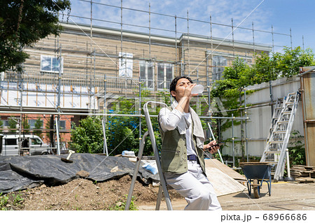 工事現場で水を飲む作業員の男性 工事現場で水を飲む作業員の男性 68966686