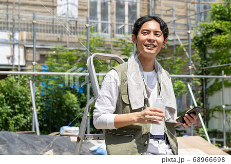 工事現場でスマホを使う作業員の若い男性 68966698