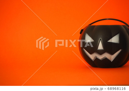オレンジ背景画用紙の上に並べたハロウィングッズ 横長 左余白 の写真素材