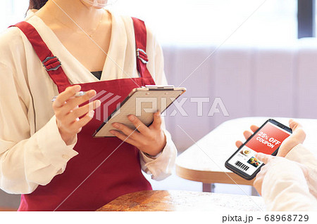 グルメクーポンを提示するお客の手元 グルメクーポンを提示するお客の手元 68968729