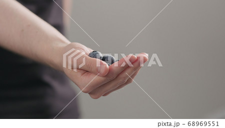 man hand show big ripe blueberries on neutral background 68969551