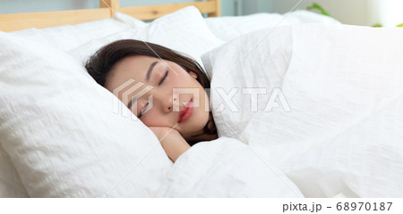 Asian women sleeping and sweet dream on white bed in bedroom Asian women sleeping and sweet dream on white bed in bedroom 68970187