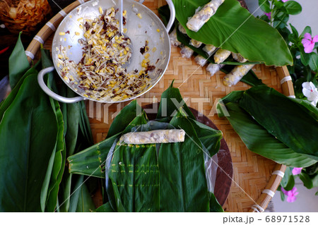 doing Vietnamese vegetarian dish, make deep fried corn spring roll, vegan food in leaf background doing Vietnamese vegetarian dish, make deep fried corn spring roll, vegan food in leaf background 68971528