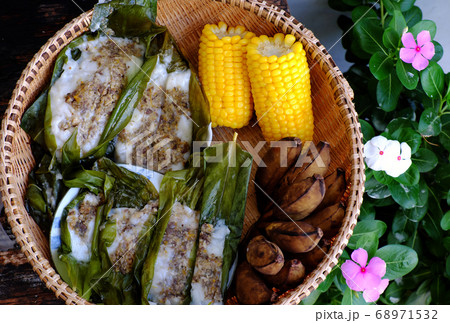 basket of Vietnamese homemade food, boiled yellow corn, steam banana and vegan rice cake that wrap by leaf basket of Vietnamese homemade food, boiled yellow corn, steam banana and vegan rice cake that wrap by leaf 68971532