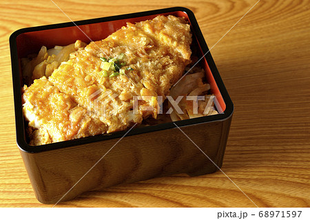 かつ重はトンカツと玉ねぎを煮込みそして卵でとじたものをお重に入れ、最後に万能ねぎを乗せた食べ物です かつ重はトンカツと玉ねぎを煮込みそして卵でとじたものをお重に入れ、最後に万能ねぎを乗せた食べ物です 68971597