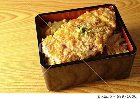 かつ重はトンカツと玉ねぎを煮込みそして卵でとじたものをお重に入れ、最後に万能ねぎを乗せた食べ物です かつ重はトンカツと玉ねぎを煮込みそして卵でとじたものをお重に入れ、最後に万能ねぎを乗せた食べ物です 68971600