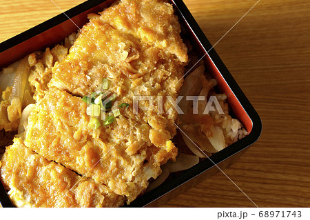 かつ重はトンカツと玉ねぎを煮込み、卵でとじたものをお重に入れ万能ねぎを乗せた食べ物です(俯瞰) かつ重はトンカツと玉ねぎを煮込み、卵でとじたものをお重に入れ万能ねぎを乗せた食べ物です(俯瞰) 68971743