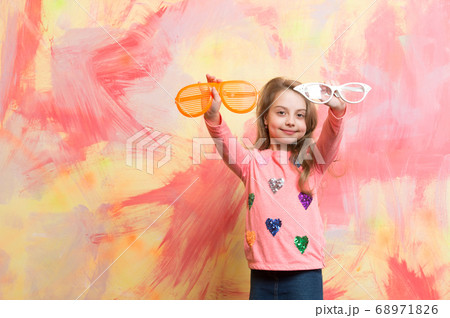 Girl smiling with two funny sunglasses Girl smiling with two funny sunglasses 68971826
