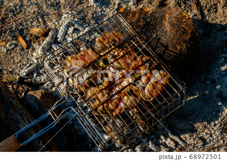Grilling catfish slices in portable barbecue grill Grilling catfish slices in portable barbecue grill 68972501