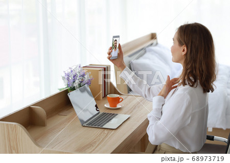 Young attractive caucasian woman VDO call to her boyfriend by using cell phone in bedroom 68973719