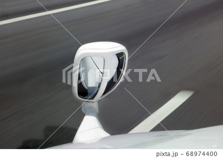 a fender mirror on the bonnet of white car while 68974400