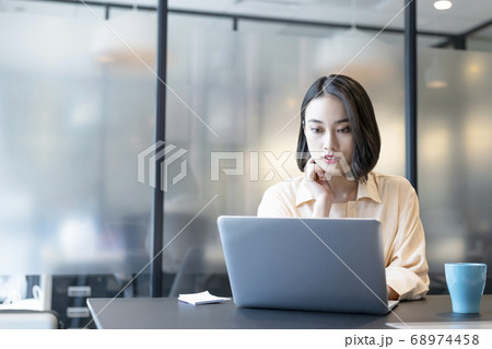 個室に籠って集中して仕事を進めるキャリアウーマン 68974458