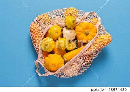 Yellow zucchini and pattison on blue background 68974489