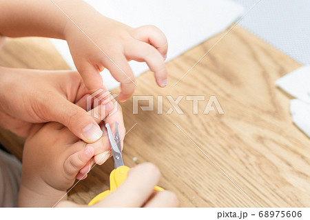 母親が子供の爪を切る様子　ハサミで幼女の爪を切る 68975606