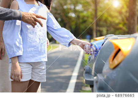 asian family in the park, parents teaching children to throw empty plastic bottle into the garbage 68976665