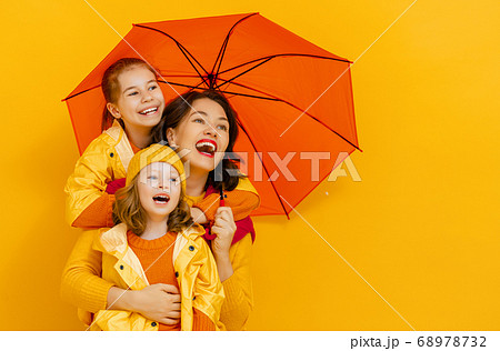 Family with umbrella on colored background. Family with umbrella on colored background. 68978732