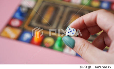 Hand throws the dice on the background of colorful blurred Board games 68978835