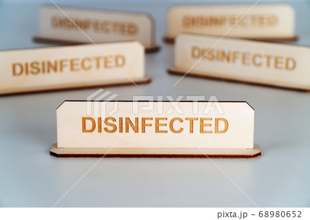 COVID-19. Wooden name plate with inscription DISINFECTED 68980652