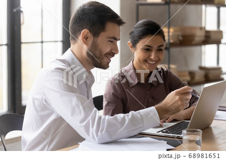 Smiling young mixed race managers working on online project. 68981651
