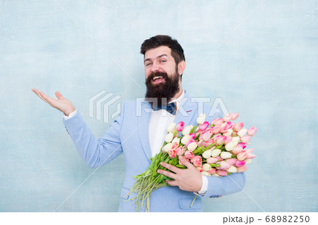 Flower bouquet for womens day. Bearded man with 68982250