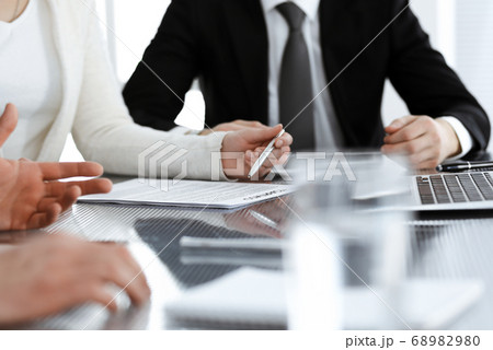 Business people discussing contract working together at meeting in modern office. Unknown businessman and woman with colleagues or lawyers at negotiation 68982980