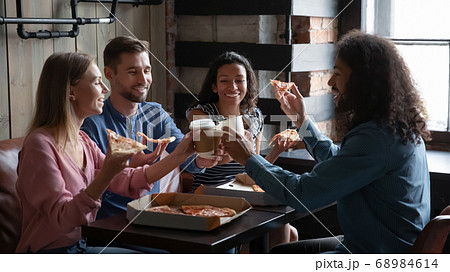 Happy diverse friends eating pizza and having fun in cafe 68984614