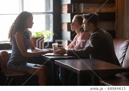 African American advisor consulting young married couple at meeting 68984615