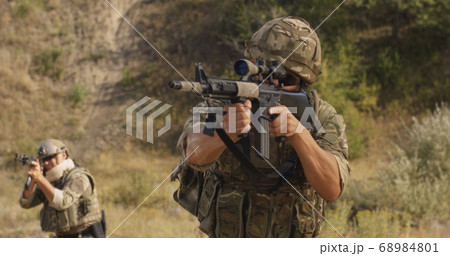 Male soldier reloading firearm during war 68984801