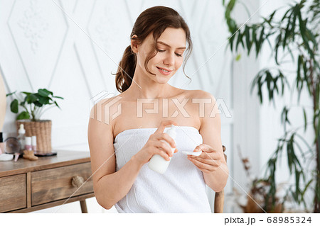 Beautiful girl cleaning makeup with face lotion at home Beautiful girl cleaning makeup with face lotion at home 68985324