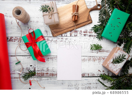 a sheet of paper lies on a white table next to gifts 68986555