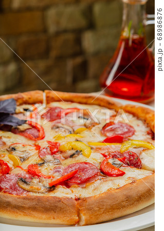 Fresh hot pizza on white plate in restaurant. Fresh hot pizza on white plate in restaurant. 68986876