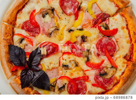 Fresh hot pizza on white plate in restaurant. Fresh hot pizza on white plate in restaurant. 68986878