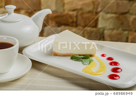 Fresh cheesecake on a white plate with jam in a 68986949