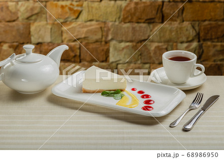 Fresh cheesecake on a white plate with jam in a 68986950