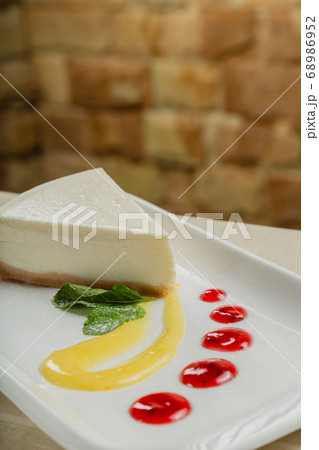 Fresh cheesecake on a white plate with jam in a 68986952