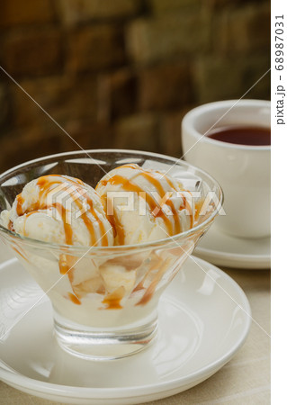 White ice cream in a glass glass with caramel. White ice cream in a glass glass with caramel. 68987031