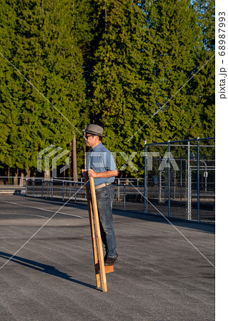 サングラスをかけた中年男性が竹馬に乗る様子　　バンクーバー　ブリティッシュコロンビア　カナダ 68987993