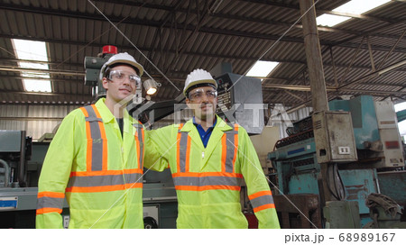 Group of factory workers using machine equipment in factory workshop Group of factory workers using machine equipment in factory workshop 68989167