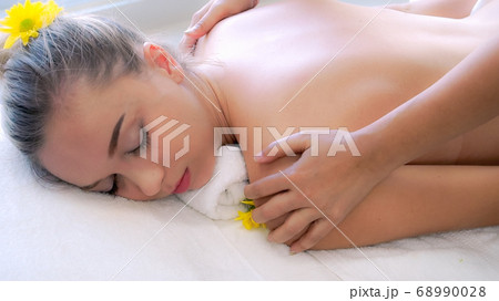 Woman gets back massage spa by massage therapist. Woman gets back massage spa by massage therapist. 68990028