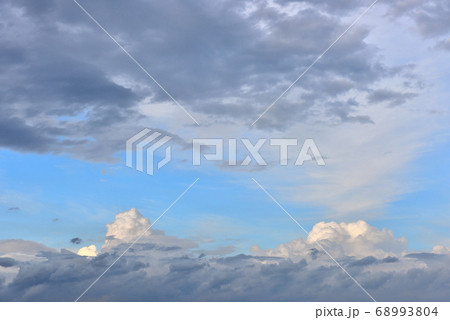 湘南の海にかかる白い雲と黒い雲の写真素材