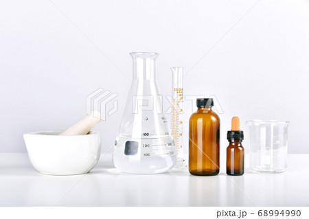 Group of scientific laboratory glassware with medicine bottles and clear liquid solution Group of scientific laboratory glassware with medicine bottles and clear liquid solution 68994990