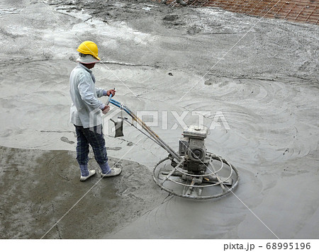 KUALA LUMPUR, MALAYSIA -JULY 16, 2017: Power float works by construction workers at the construction site. Power float machine was used to level wet concrete. KUALA LUMPUR, MALAYSIA -JULY 16, 2017: Power float works by construction workers at the construction site. Power float machine was used to level wet concrete. 68995196