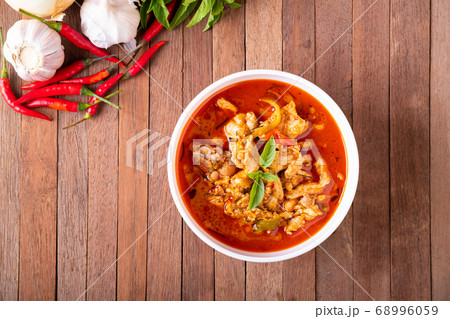 Thai curry red soup,Thailand tradition menu,boiled red curry with coconut milk and chicken on wood table Thai curry red soup,Thailand tradition menu,boiled red curry with coconut milk and chicken on wood table 68996059