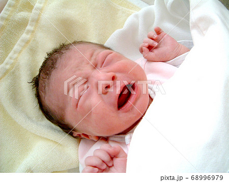 生まれたての泣いている新生児 の写真素材