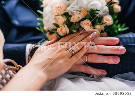 hands of the bride and groom with gold rings on the wedding day together 68998052